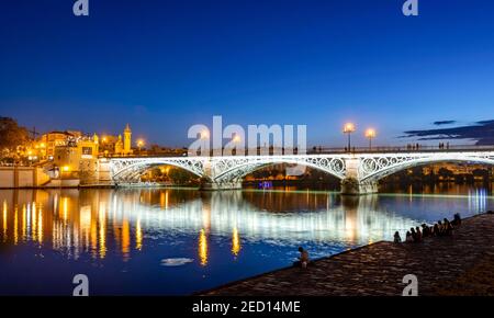 Beleuchtete Brücke Puente de Triana über den Fluss Rio Guadalquivir, blaue Stunde, Sevilla, Andalusien, Spanien Stockfoto