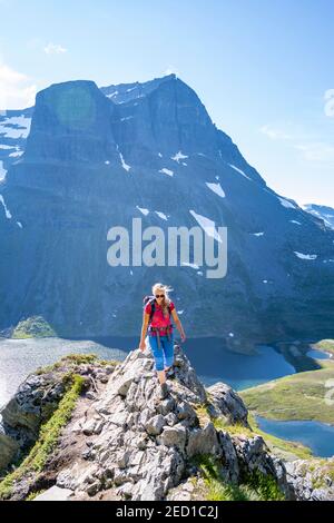 Wanderer auf dem Weg nach Innerdalstarnet, hinter See Storvatnet und Berg Skarfjell, Innerdalen, Trollheimen Berggebiet, Sunndal, Mehr OG Stockfoto