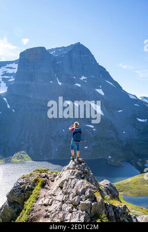 Wanderer auf dem Weg nach Innerdalstarnet, hinter See Storvatnet und Berg Skarfjell, Innerdalen, Trollheimen Berggebiet, Sunndal, Mehr OG Stockfoto