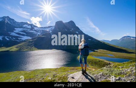 Wanderer auf dem Weg nach Innerdalstarnet, hinter See Storvatnet und Berg Skarfjell, Innerdalen, Trollheimen Berggebiet, Sunndal, Mehr OG Stockfoto