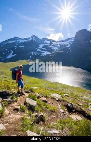 Wanderer auf dem Weg nach Innerdalstarnet, hinter See Storvatnet und Berg Skarfjell, Innerdalen, Trollheimen Berggebiet, Sunndal, Mehr OG Stockfoto