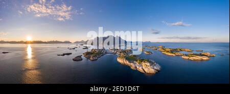 Luftaufnahme, Sonnenuntergang über Henningsvaer mit Fußballstadion, Felseninseln im Meer vor Bergen, Festvagtinden, Vestvavoy, Lofoten, Nordland Stockfoto