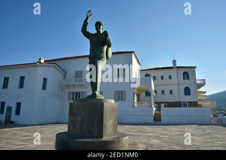 Neoklassizistische Villen mit der Bronzestatue, die dem unbekannten Seefahrer gewidmet ist, im Vordergrund auf dem Hauptplatz von Chora, Andros Insel Kykladen, Griechenland. Stockfoto