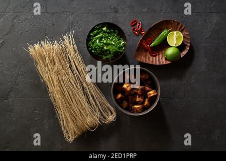 Zutaten zum Kochen vegetarische Ramen mit Tofu auf die gelegt Dunkler Hintergrund Stockfoto