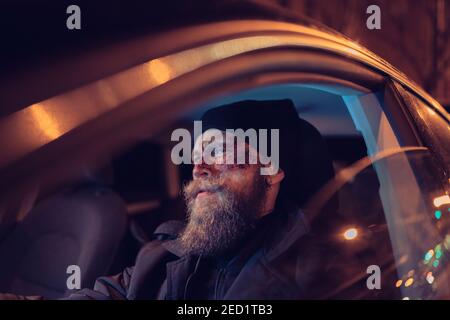 Hipster Mann mit Bart und Kino Make-up fahren ein Auto Stockfoto