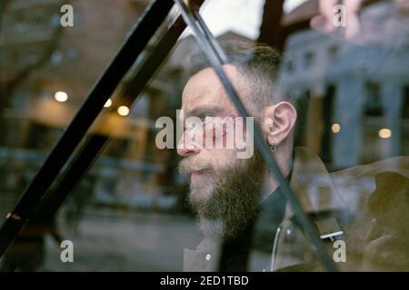 Seitenansicht Hipster Mann mit Bart und Kino Make-up posiert Auf der Straße Stockfoto