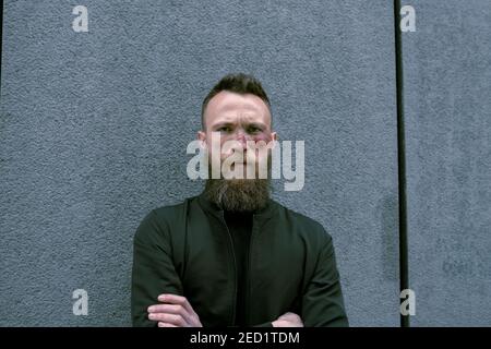 Hipster Mann mit Bart und Kino Make-up posiert auf der Straße und Blick auf die Kamera Stockfoto