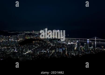 Spektakuläre Aussicht auf Busan Stadt mit modernen Gebäuden und Wolkenkratzern Beleuchtet mit Lichtern unter dunklem Himmel in der Nacht Stockfoto