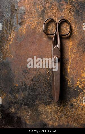 Draufsicht der alten Metallschere auf dunklem Tisch platziert Mit rostiger Oberfläche Stockfoto