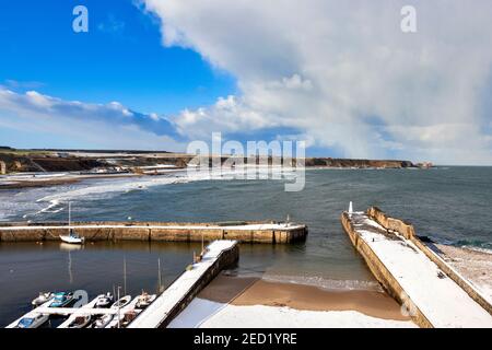 CULLEN BAY MORAY FIRTH SCHOTTLAND WINTERTAG MIT SCHNEE AUF DER STRAND UND DER HAFEN ODER DIE ANLEGESTELLE Stockfoto