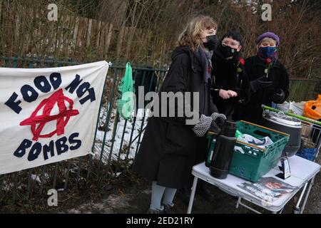 Glasgow, Großbritannien, am 14. Februar 2021. Drei Freiwillige der Organisation "Food not Bombs (Glasgow)" geben heiße Suppe und vegane Haggis im Queen's Park aus. Dies ist das Wochenende 4th des Standes, der Nahrung, gespendet von lokalen Unternehmen, für jeden, der es wünscht, und Kleidung für die Bedürftigen, in der Stadt Southside während der aktuellen Coronavirus Covid-19 Gesundheitspandemie. Foto: Jeremy Sutton-Hibbert/ Alamy Live News. Stockfoto