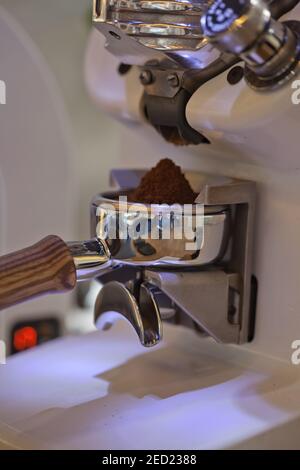 Makro von gemahlenem Kaffee in Espressohalter, moderne Mühle, Nahaufnahme Stockfoto