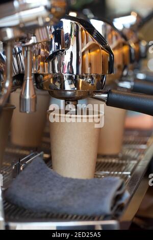Nahaufnahme der modernen professionellen Espressomaschine im Café mit Kaffeeausguss in Take Away Pappbecher, niemand Stockfoto