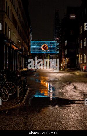 Kultige Neonuhr, die sich in der Straße spiegelt Stockfoto