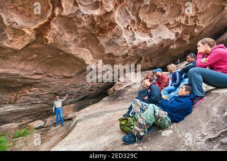 Bob White, freiwilliger Reiseleiter, Besucher in Cave mit Mescalero Apache Piktograph, Hueco Tanks State Park und historische Stätte, in der Nähe von El Paso, Texas, USA Stockfoto