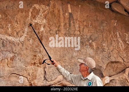 Bob White, freiwilliger Reiseleiter, in der Höhle mit Piktografen im mittel/spätarchaischen Stil (3000 v. Chr. bis 450 n. Chr.), Hueco Tanks State Park, Texas, USA Stockfoto