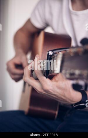 Detail auf den Fingern des Künstlers, wie sie über das Instrumentalinstrument blättern, um den richtigen Klang zu machen. Business as usual. Ein Mann mittleren Alters spielt sein Stockfoto