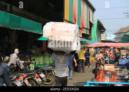 bangkok, thailand- januar 3 2020: Der nicht identifizierte thailändische Arbeiter trägt die Kunststoffbox auf dem Markt. Kunststoffbox ist immer noch beliebt im Leben verwendet Stockfoto