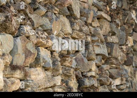 Handgewebte alte Steinmauer im Dorf. Stockfoto