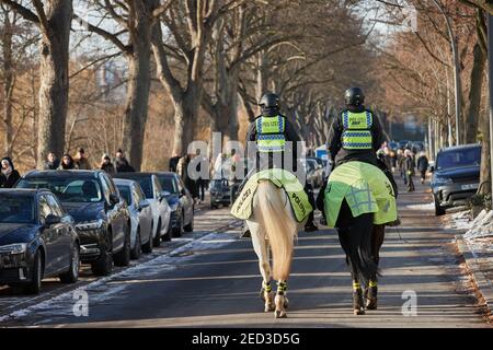 Hamburg, Deutschland. Februar 2021, 14th. Eine Polizistin und ein Polizist patrouillieren die Alster zu Pferd. Das Stepping auf Eis ist in Hamburg verboten. Quelle: Georg Wendt/dpa/Alamy Live News Stockfoto