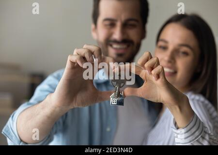 Glückliches Paar machen Finger Herz demonstrieren Tasten aus dem neuen Zuhause Stockfoto