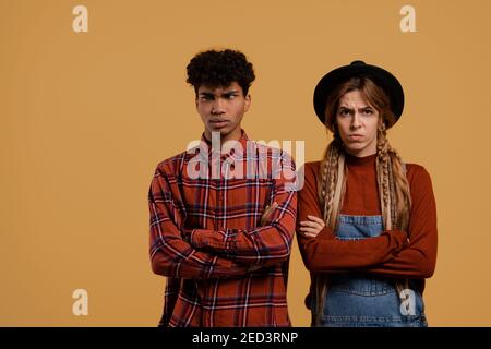 Foto von niedlichen paar Bauern streiten über etwas und sprechen nicht miteinander. Schwarzer Mann trägt kariertes Hemd, weiße Frau trägt Denim-Overall und Hut Stockfoto