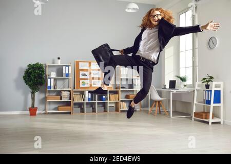 Lustige Büroangestellte ist glücklich, dass der Arbeitstag vorbei ist und Springt hoch bereit, nach Hause zu laufen Stockfoto