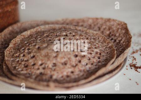 Trichter aus Fingerhirse auch bekannt als Ragi in Indien. Hausgemachte gesunde Lebensmittel auf weißem Hintergrund geschossen. Stockfoto