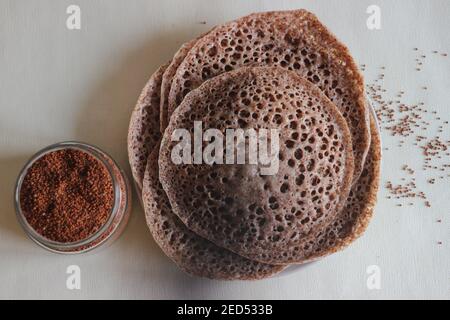 Trichter aus Fingerhirse auch bekannt als Ragi in Indien. Hausgemachte gesunde Lebensmittel auf weißem Hintergrund geschossen. Stockfoto