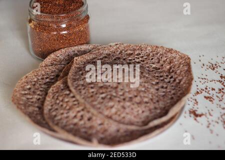 Trichter aus Fingerhirse auch bekannt als Ragi in Indien. Hausgemachte gesunde Lebensmittel auf weißem Hintergrund geschossen. Stockfoto