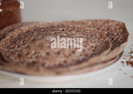 Trichter aus Fingerhirse auch bekannt als Ragi in Indien. Hausgemachte gesunde Lebensmittel auf weißem Hintergrund geschossen. Stockfoto