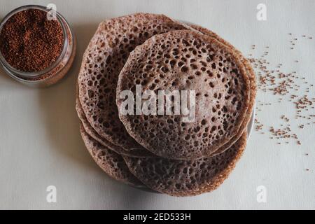 Trichter aus Fingerhirse auch bekannt als Ragi in Indien. Hausgemachte gesunde Lebensmittel auf weißem Hintergrund geschossen. Stockfoto