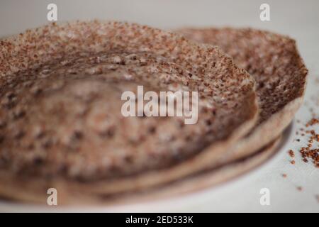 Trichter aus Fingerhirse auch bekannt als Ragi in Indien. Hausgemachte gesunde Lebensmittel auf weißem Hintergrund geschossen. Stockfoto