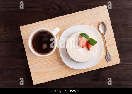 Käsekuchen und eine Tasse Kaffee auf Holztablett. Schönes Frühstück. Top Vie Stockfoto