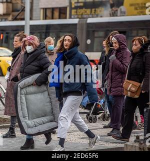 Prag, Tschechische Republik. 02-13-2021. An einem kalten Wintertag durchqueren Frauen die Eisenbahn im Stadtzentrum von Prag. Stockfoto