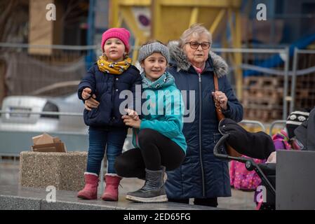 Prag, Tschechische Republik. 02-13-2021. Zwei Kinder mit ihrer Oma im Zentrum von Prag während eines kalten Wintertages. Stockfoto