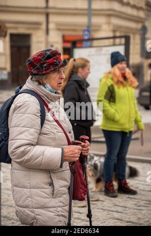 Prag, Tschechische Republik. 02-13-2021. Alte Frau mit Wanderstöcken im Stadtzentrum von Prag während eines kalten Wintertages. Stockfoto