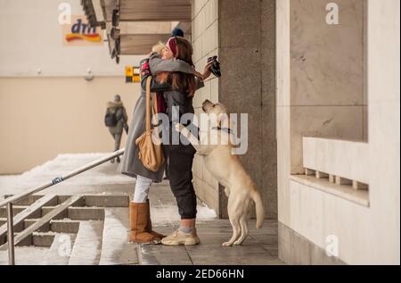 Prag, Tschechische Republik. 02-13-2021. Emotionaler Moment von zwei Freundinnen umarmt, wenn sie mit dem Hund teilnehmen an der Wiedervereinigung in der Stadt treffen Stockfoto