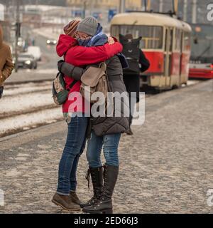 Prag, Tschechische Republik. 02-13-2021. Emotionaler Moment von zwei Freundinnen umarmt, wenn sie mit dem Hund teilnehmen an der Wiedervereinigung in der Stadt treffen Stockfoto