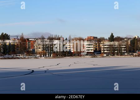 Schöne Winteransicht mit gefrorener Oberfläche des Sees Valkeinen und Gebäuden um ihn herum, Kuopio, Finnland, November 2019. Sehr beliebte Sehenswürdigkeit! Stockfoto