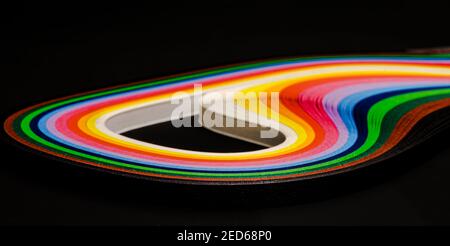 Abstrakte Farbe Welle curl Regenbogen Streifen Papier auf schwarzem Hintergrund Stockfoto