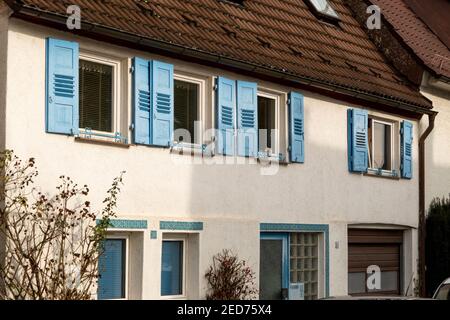 Haus mit Fenstern und blauen Fensterläden Stockfoto