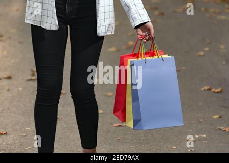 Mehrfarbige Papier-Einkaufstaschen in weiblicher Hand. Verkauf und Einkaufen. Stockfoto