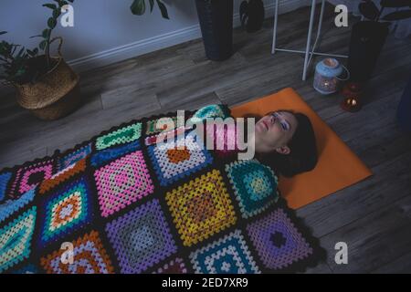 Frau, die in Shavasana liegt und sich nach der Yoga-Praxis ausruhte Stockfoto