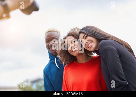Multi ethnische Freunde im Freien auf Foto-Shooting Blick auf die Kamera. Diverse Gruppe Menschen Afro american Asian verbringen Zeit zusammen multirassischen männlichen weiblichen Studenten Treffen im Freien für Foto Stockfoto
