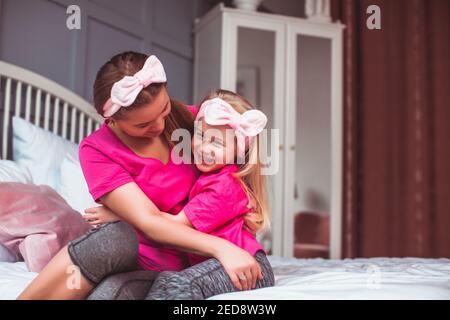 Sanfte Umarmungen von Mutter und Tochter nach dem Aufwachen Stockfoto