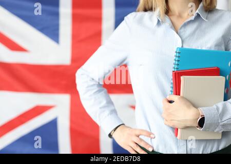 Frau hält Notizbücher und Tagebücher vor dem Hintergrund der Flaggen Großbritannien Stockfoto