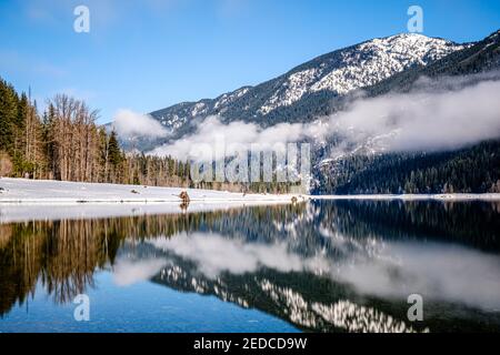 CLE Elum, WA, USA - Januar 23 2021: Berg und Wolken spiegeln sich am Kachess See Stockfoto