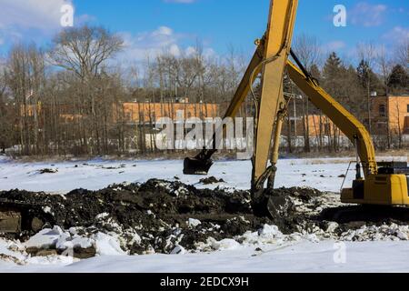 Bagger baggern und säubern einen See den Winterschnee Des Seegrunds Stockfoto