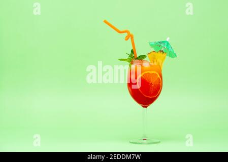 Buntes alkoholisches Cocktail-Getränk im Glas mit eingekeilter Ananas, Minze und Regenschirm Stockfoto